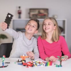 Shows a boy and a girl playing with Plus Plus