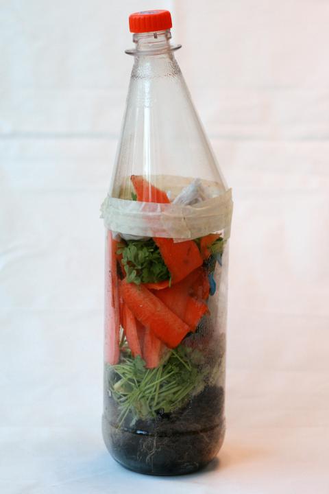 Shows a bottle with waste about to be turned into compost to illustrate the topic of this experiment