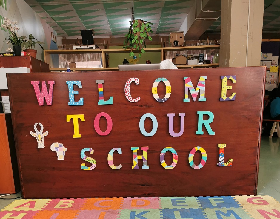 Shows a sign that says "welcome to our school" to illustrate the topic of the article which is the secret to good teaching