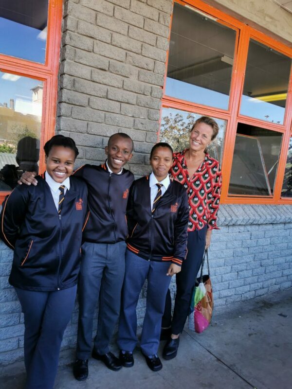 Shows students outside the school smiling to illustrate the topic which is the secret to good teaching